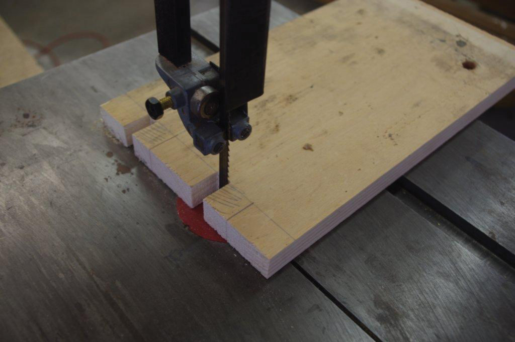 Using the band saw to remove the wood that creates the fingers.