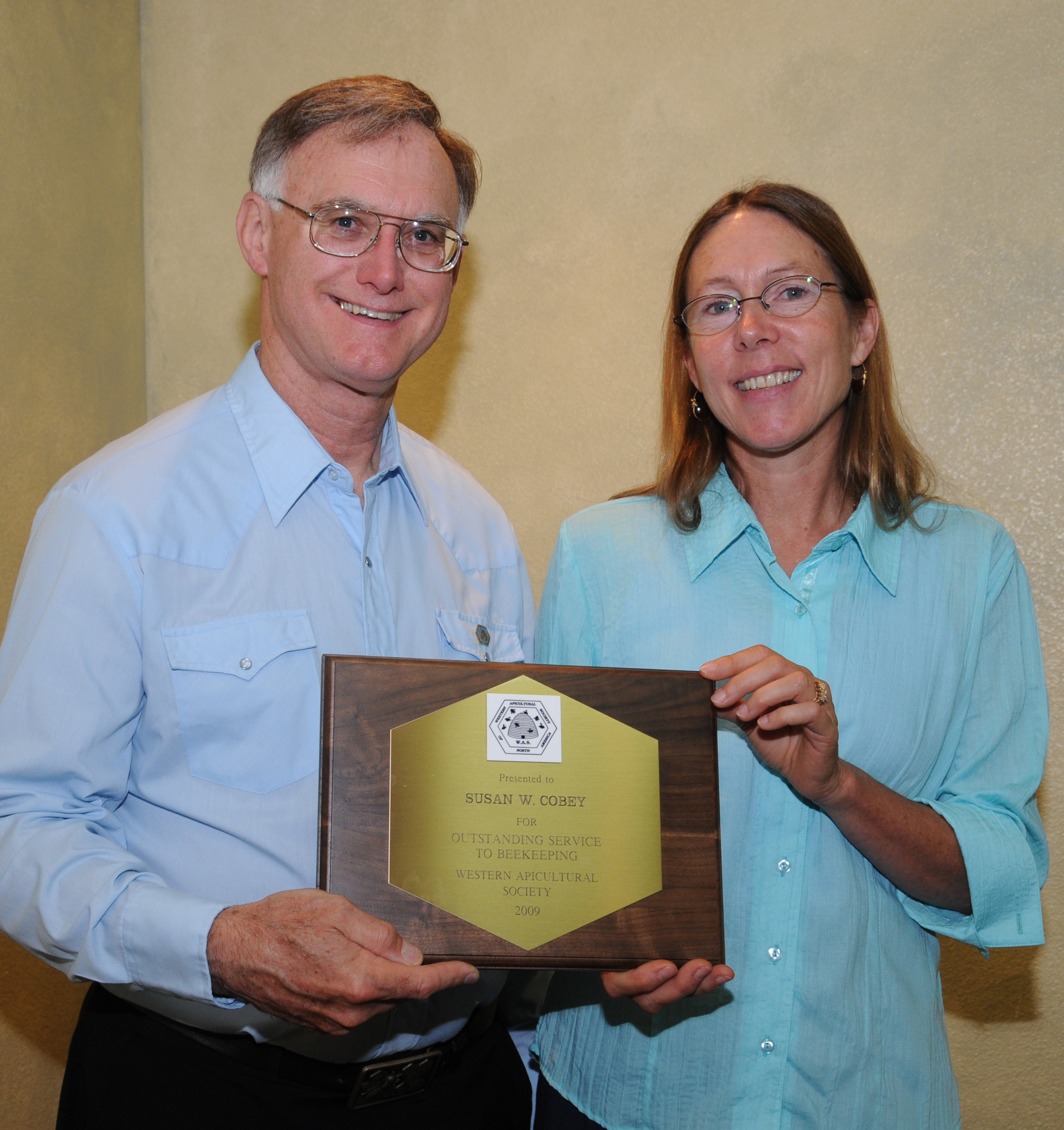 In this 2014 image, taken at the Western Apicultural Society meeting, Eric Mussen presents an award to Susan Cobey, then a bee breeder-geneticist at UC Davis, and now with Washington State University. Cobey said of the June 3 passing of Mussen:  